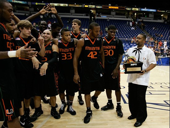 Miami's head coach Frank Haith, right, shows the trophy to his players after winning the Puerto Rico Tip-Off college basketball tournament in San...