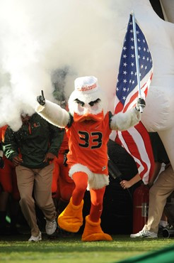 Sebastian the Ibis leads the University of Miami Hurricanes through a tunnel of smoke in a game against the Virginia Tech Hokies at Sun Life Stadium...
