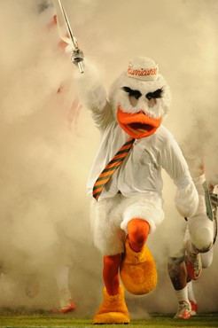 Sebastian the Ibis leads the University of Miami Hurricanes through a tunnel of smoke in a game against the Virginia Cavaliers at Sun Life Stadium on...
