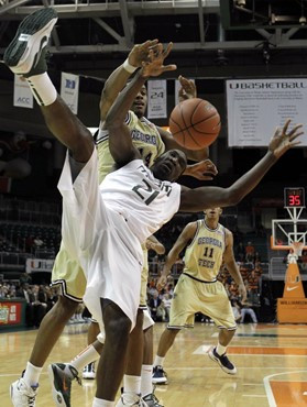 Georgia Tech forward Derrick Favors, left, and Miami forward Dwayne Collins (21) fight for a loose ball in the first half during an NCAA college...