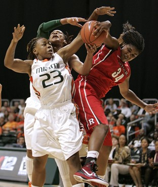 Miami's Shanel Williams, left, Maria Brown, center, and Rutgers' Monique Oliver, right, fight for the ball during the first half of an NCAA basketball...