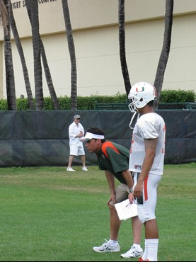 Coach Fisch watches the quarterback during a play. Stephen Morris stands alongside.
