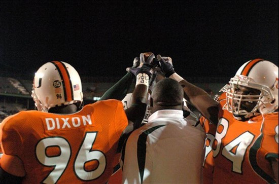 University of Miami players hold hands in na sign of unity before a game against Boston College. The Hurricanes and Boston College players wore Bryan...