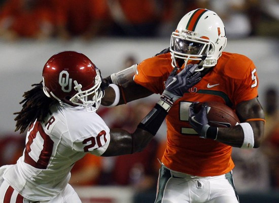 Javarris James uses the stiff arm on Oklahoma defensive back Quinton Carter.