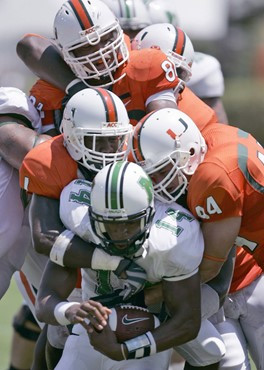 Marshall quarterback Bernard Morris, foreground bottom, is sacked by a mass of Miami players during the first quarter of a football game Saturday,...