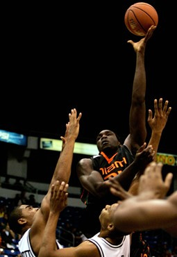 Miami's Dwayne Collins, center, shoots over Providence's Geoff McDermott, left, and Jonathan Kale during the first half of the championship game of...