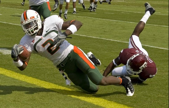 Graig Cooper dives into the end zone for on a 19-yard touchdown run as Danny Gorrer tries to defend during the first quarter.