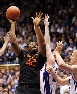 Miami's Reggie Johnson (42) shoots over Duke's Ryan Kelly, Mason Plumlee, right, and Nolan Smith, left. Duke won 74-63 over Miami. (AP Photo/Sara D....