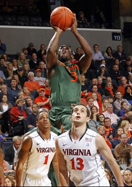 Miami guard Malcolm Grant (3) shoots over Virginia guard Jontel Evans (1) and guard Sammy Zeglinski (13) during the first half. (AP Photo/Andrew...