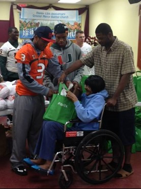 Seven football players and other staff delivered 48 turkey dinners to the Greater Mercy Missionary Baptist Church in Overtown.