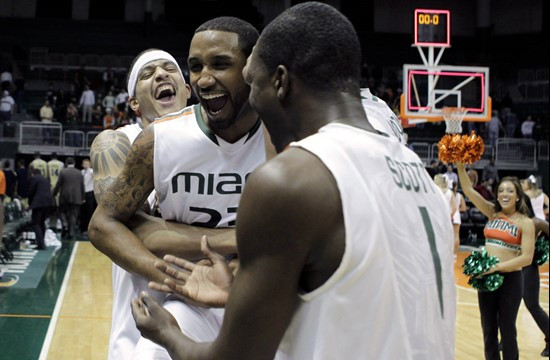 Miami center Julian Gamble, left, hugs guard James Dews, center, after Dews made the game-winning shot to defeat Georgia Tech 64-62 during an NCAA...