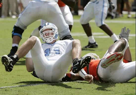 North Carolina quarterback Cam Sexton (11) is sacked for a 6-yard loss by Miami's Calais Campbell, right, in the first quarter of a college football...