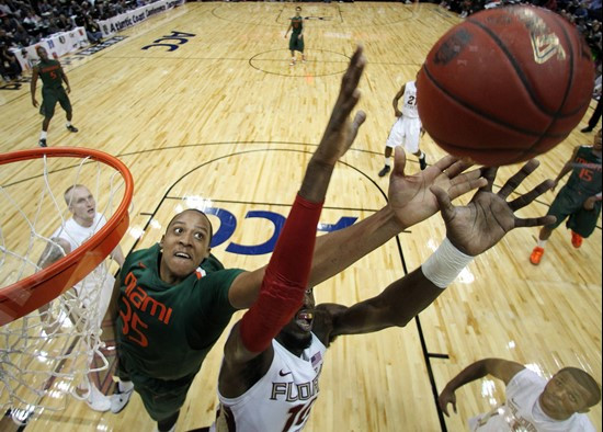 Miami forward/center Kenny Kadji (35) and Florida State forward Okaro White (10) vie for a rebound during the first half of an NCAA college basketball...