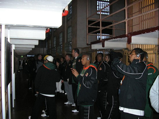 Players from both teams look into cells while listening to the Alcatraz audio tour.