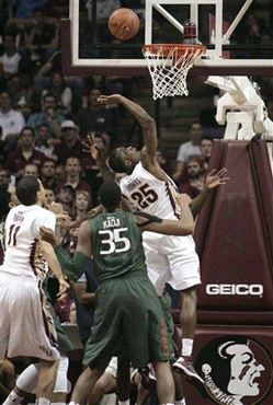 Florida State's Aaron Thomas (25) looks up at the ball in front of Miami's Kenny Kadji (35) during the first half of an NCAA college basketball game...