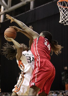 Miami's Sylvia Bullock, left, drives to the basket while Rutgers forward Monique Oliver, right, defends during the first half of an NCAA basketball...