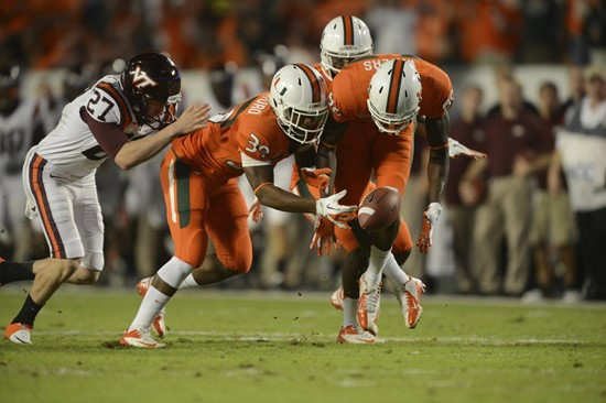  University of Miami Hurricanes defensive back Antonio Crawford #39 and Herb Waters #86 scramble to recover the ball after a blocked punt in a game...