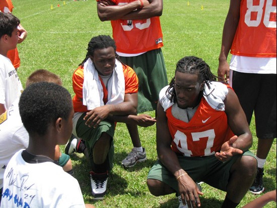 Thearon Collier (l) and Laron Byrd speak to kids about the wide receiver position at the Ezell Hester Community Center