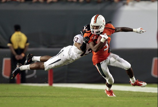Virginia's Chase Minnifield (13) tries to tackle Miami's Travis Benjamin (3) in the first half of an NCAA college football game in Miami, Thursday,...