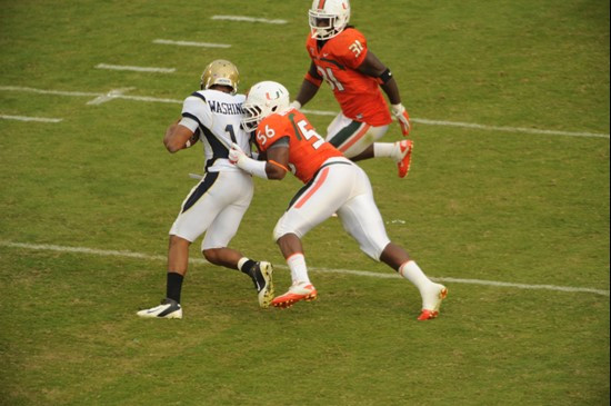 University of Miami Hurricanes linebacker Marcus Robinson #56 makes a tackle on Georgia quarterback Demond Smith #12 in a game against the Yellow...
