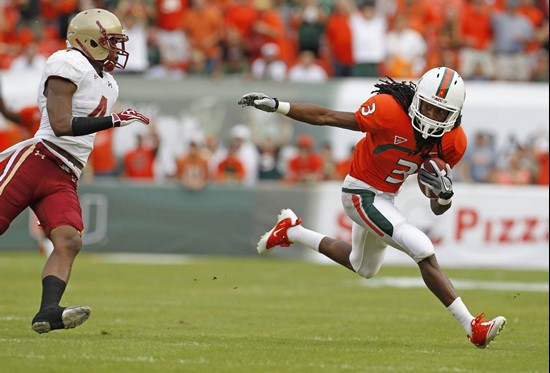Miami's Travis Benjamin , right, out maneuvers Boston College's Donnie Fletcher during an NCAA college football game, Friday, Nov. 25, 2011 in Miami....