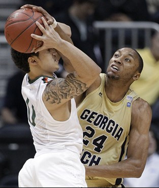 Miami guard Shane Larkin (0) tries to keep the ball from Georgia Tech forward Kammeon Holsey (24) during the second half. (AP Photo/Chuck Burton)