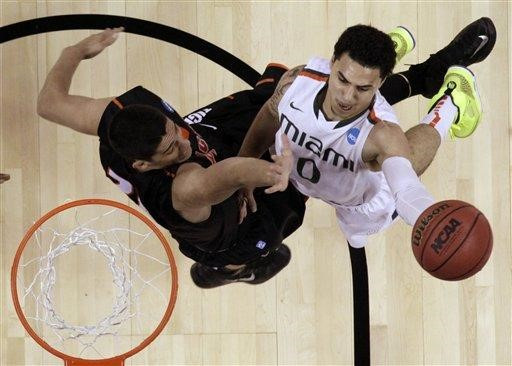 Miami's Shane Larkin shoots past Pacific's Rodrigo De Souza during the first half of a second-round game of the NCAA college basketball tournament...