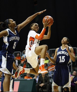 Miami guard Suriya McGuire, center, goes up for a shot against Longwood forward Brittanni Billups (5) and guard/forward Chelsea Coward (15). (AP...