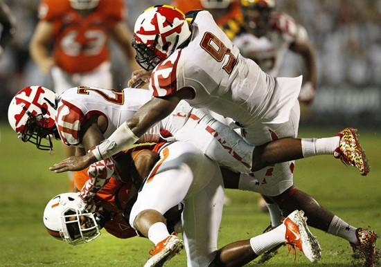 Miami wide receiver Tommy Streeter, bottom left, is tackled by Maryland defenders Cameron Chism, center, and Demetrius Hartsfield (9) during the...