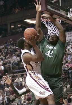 Florida State's Ian Miller tries to get to the basket as Miami's Reggie Johnson defends during the first half of an NCAA college basketball game...