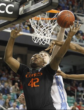 Miami's Reggie Johnson, front, shoots as North Carolina's Tyler Zeller, back, defends in the first half of an NCAA college basketball game at the...
