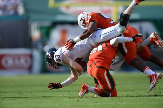 University of Miami Hurricanes defensive back Antonio Crawford #21 and linebacker Raphael Kirby take down Virginias wide receiver at Sun Life Stadium...