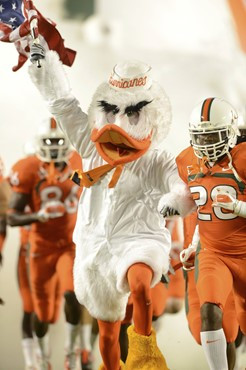 Sebastian the Ibis leads the University of Miami Hurricanes through a tunnel of smoke in a game against the Virginia Tech Hokies at Sun Life Stadium...