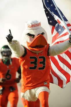 Sebastian the Ibis leads the University of Miami Hurricanes through a tunnel of smoke in a game against the Virginia Tech Hokies at Sun Life Stadium...