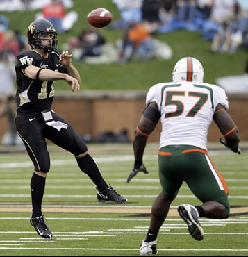 e Forest's Riley Skinner (11) throws a pass as he is pressured by Miami's Allen Bailey (57) in the first half of a NCAA college football game in...