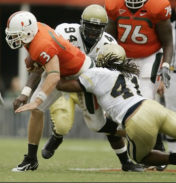 Miami quarterback Kyle Wright (3) is taken down by Georgia Tech defensive tackle Elris Anyaibe, (94) and linebacker Philip Wheeler as he runs for...