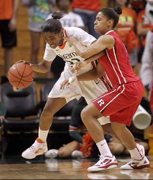 Miami's Morgan Stroman, left, drives past Rutgers' Nikki Speed, right, during the first half of an NCAA basketball game, Monday Dec. 5, 2011 in Coral...