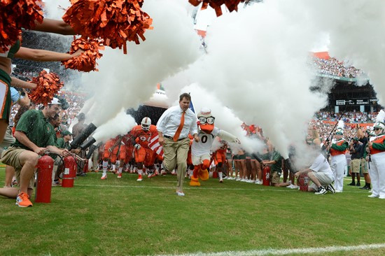 Sebastian the Ibis and coach Al Golden leads the University of Miami Hurricanes through a tunnel of smoke in a game against the #12 ranked University...