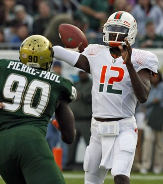 Miami quarterback Jacory Harris (12) fires a second-quarter pass as South Florida defensive end Jason Pierre-Paul rushes during an NCAA college...