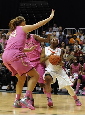 Miami's Riquna Williams, right, is defended by Florida State's Cierra Bravard, left, and Natasha Howard, center, during the first half of an NCAA...