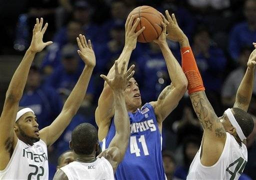 Miami defenders Donnavan Kirk (22), Dequan Jones and Julian Gamble (45) block a shot by Memphis forward Angel Garcia (41)during the first half of an...