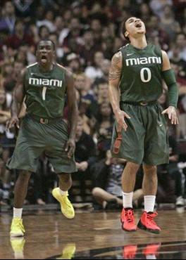 Miami's Shane Larkin, right, celebrates making a 3-point shot as teammate Durand Scott joins with him during the second half of an NCAA college...