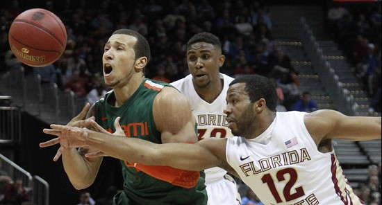 Miami guard Trey McKinney Jones (4) and Florida State guard Jeff Peterson (12) vie for a lose ball during the first half of an NCAA college basketball...