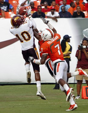 Bethune-Cookman's  Keith Stroud (10) completes a pass as Miami's Vaughn Telemaque (7) defends in the first half of an NCAA college football game in...