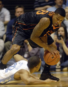 Miami's Jack McClinton, top, picks up a loose ball over North Carolina's Wayne Ellington in the first half. (AP Photo/Sara D. Davis)