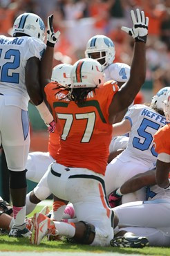 University of Miami Hurricanes offensive lineman Seantrel Henderson #77 gets set to block against the North Carolina Tar Heels at Sun Life Stadium on...