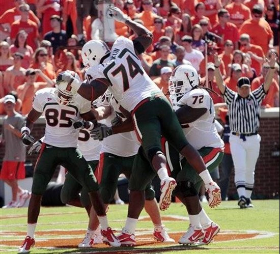 Miami's Leonard Hankerson (85) is mobbed by teammates including Orlando Franklin (74), Brandon Washington (72) after scoring a touchdown against...